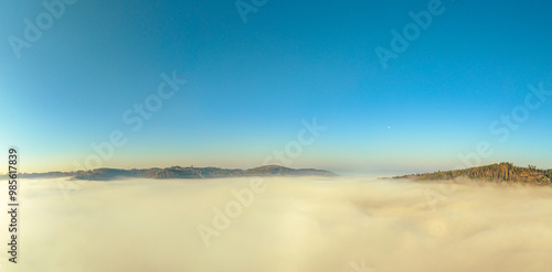 The Hohenwarte Reservoir glows in the soft morning light, shrouded in a mystical mist that envelops the surrounding nature, creating a calm and almost magical atmosphere.