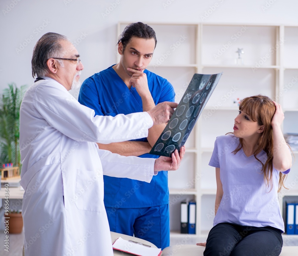 Fototapeta premium Two doctors examining young woman