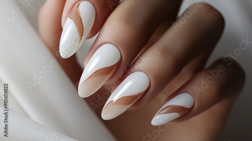 Closeup of a hand with white almond shaped nails with gold accent. photo