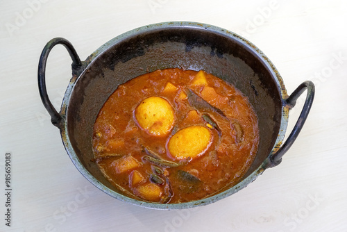 Delicious dim bhuna or dim vuna, cooked with potatoes in a karai. This delicious Bengali boiled egg curry is often enjoyed with rice or bread. photo