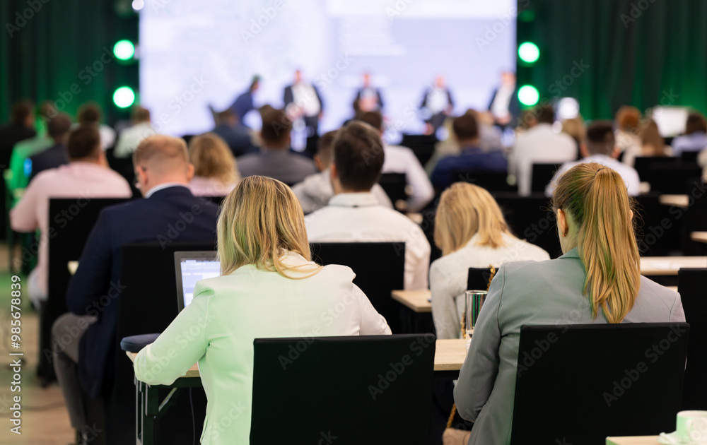 Rear view of the audience at a business conference meeting event listening to the speakers speech