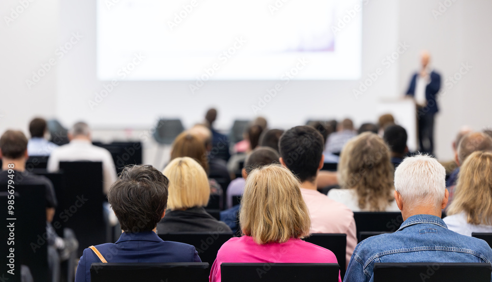 Rear view of the audience at a business conference meeting event listening to the speakers speech