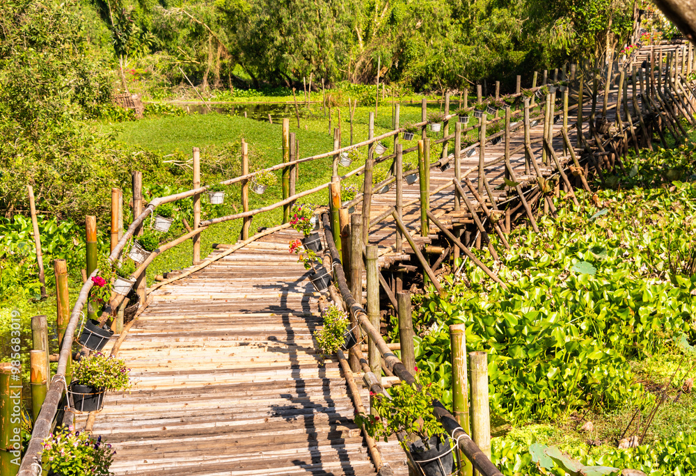 Wooden bridge in Vietnam among green tropical plants Wooden bridge in Vietnam among green tropical plants