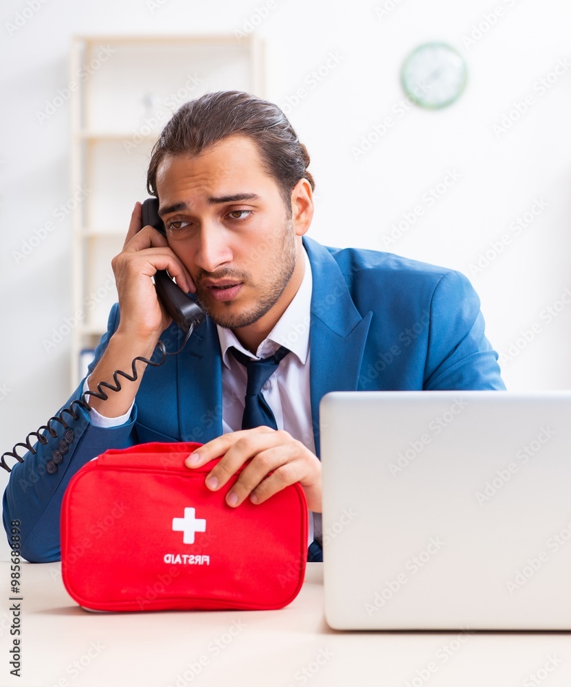 Young male employee in first aid concept