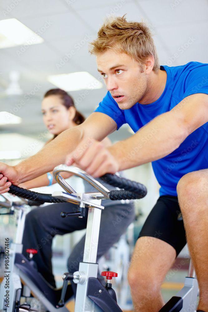 Gym, spinning class and man in training, bike and exercise for wellness, health and fitness. Athlete, active person or bicycle for cardio, strong legs or power for workout, body or sports for cycling Gym, spinning class and man in training, bike and exercise for wellness, health and fitness. Athlete, active person or bicycle for cardio, strong legs or power for workout, body or sports for cycling