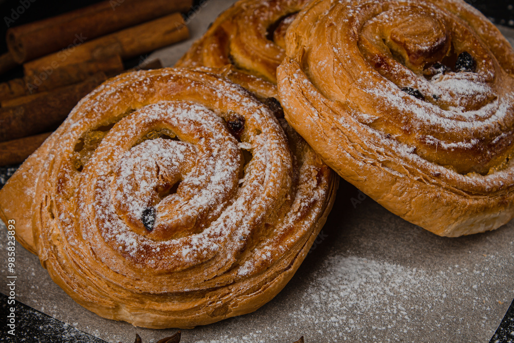 Fototapeta premium Fresh baked goods on a black background. Sweet buns