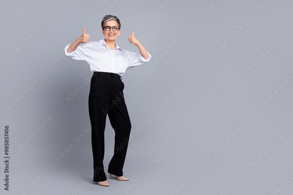 Full body photo of attractive pensioner woman thumb up approve dressed stylish formalwear isolated on gray color background Full body photo of attractive pensioner woman thumb up approve dressed stylish formalwear isolated on gray color background