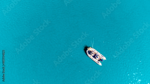 Wallpaper Mural A boat is floating on the water in a blue ocean. The boat is small and he is a fishing boat. The water is calm and the sky is clear, creating a peaceful and serene atmosphere Torontodigital.ca