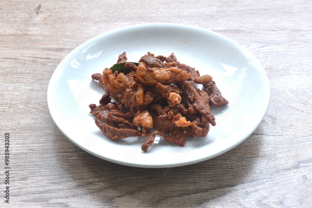 fried crispy salty fermenting beef meat with pandan and herb on plate fried crispy salty fermenting beef meat with pandan and herb on plate