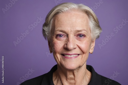 Full framed very close face portrait of a smiling senior caucasian non binary with violet eyes looking at the camera, studio shot,violet background.