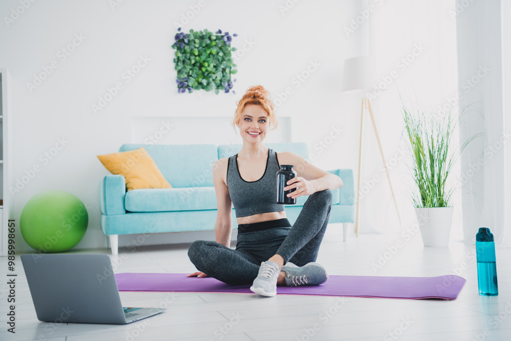 Photo of athletic active charming woman trainer watching video lesson physical exercises home house indoors Photo of athletic active charming woman trainer watching video lesson physical exercises home house indoors