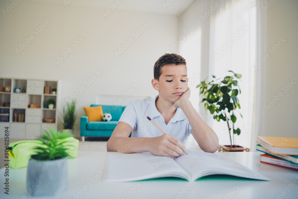 Portrait of charming little boy tired study write homework wear t-shirt modern interior flat indoors Portrait of charming little boy tired study write homework wear t-shirt modern interior flat indoors