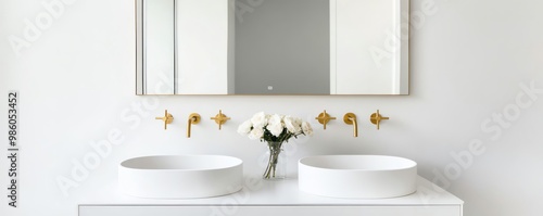 Frameless mirror above a white vanity with brass fixtures, minimalist bathroom aesthetic, sleek modern design