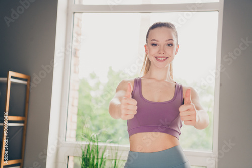 Photo of lovely adorable active confident girl in sportswear training at home good job gym indoors thumb up