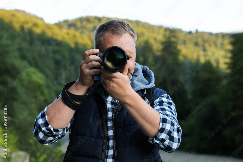 Photographer with backpack and camera in beautiful mountains Photographer with backpack and camera in beautiful mountains