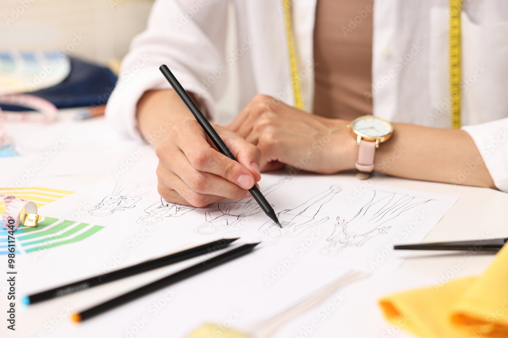 Fashion designer drawing sketch of beautiful outfit at table in workshop, closeup Fashion designer drawing sketch of beautiful outfit at table in workshop, closeup