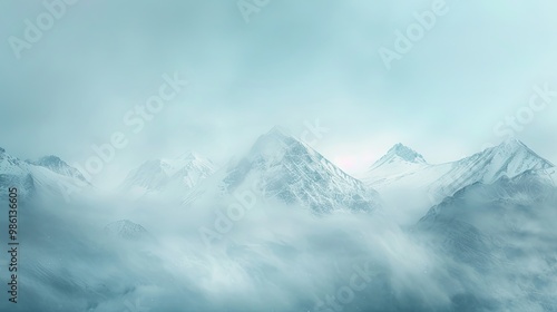 Blurred mountain range with softened snow-covered peaks under chilly cloudy sky