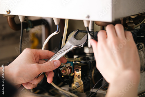 Foto A man is repairing a water-heating boiler.