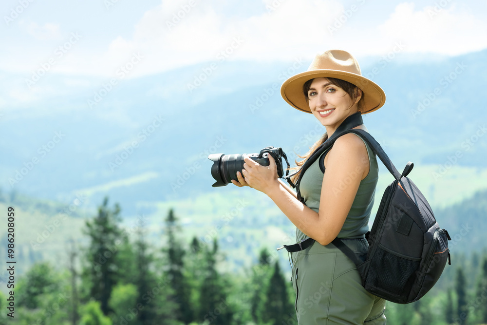 Fototapeta premium Photographer with backpack and camera in beautiful mountains. Space for text