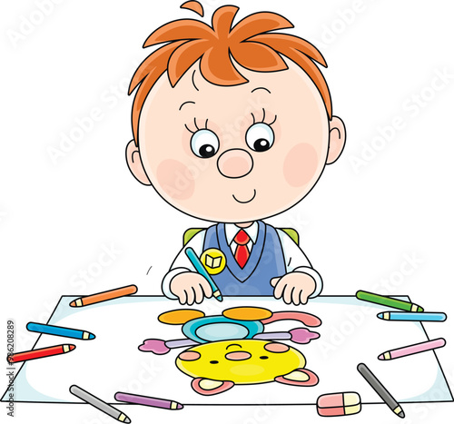 Funny little schoolboy sitting at his desk in class of primary school and drawing a funny smiling cat with color pencils on a large sheet of paper, vector cartoon illustration on a white background