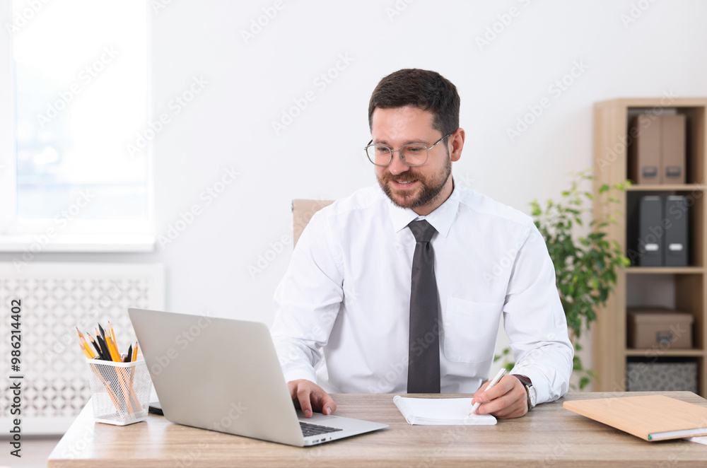 Portrait of smiling businessman working at table in office Portrait of smiling businessman working at table in office
