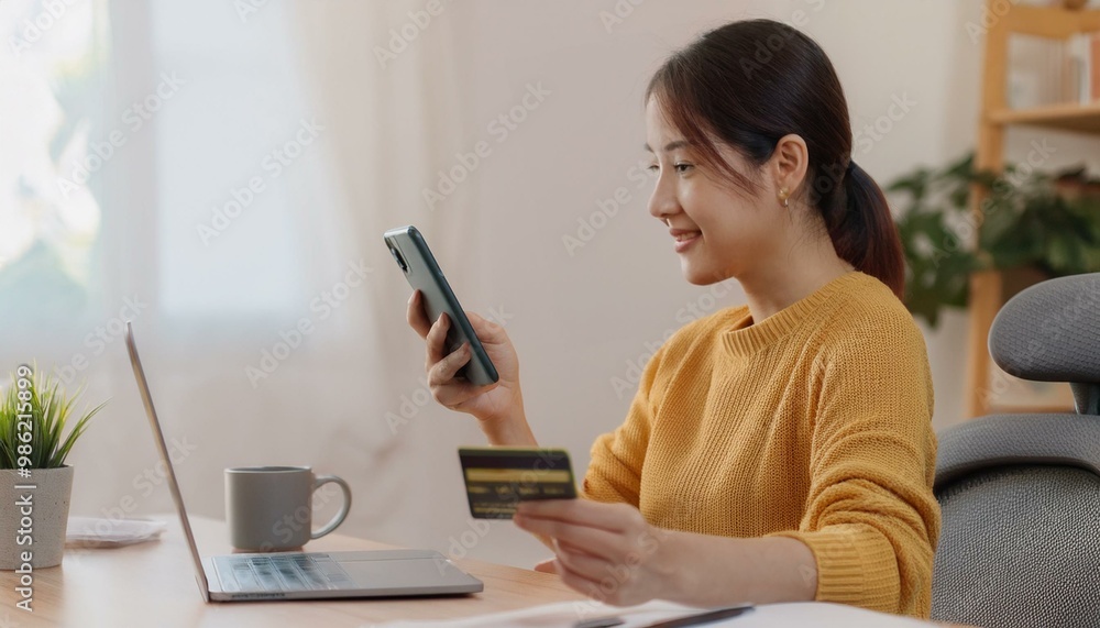Bill pay, shopping order online internet asian young woman hand holding credit card and mobile smart phone on desk at home, female using banking service to secure payment with purchase on store Bill pay, shopping order online internet asian young woman hand holding credit card and mobile smart phone on desk at home, female using banking service to secure payment with purchase on store