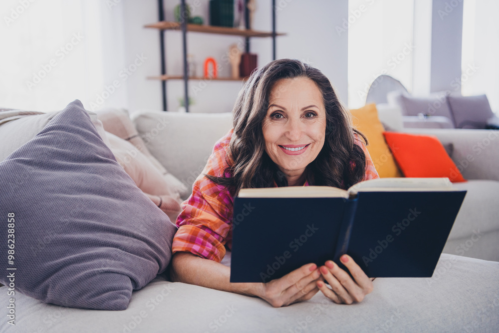 Photo of shiny cute woman dressed checkered shirt enjoying good book indoors house apartment room Photo of shiny cute woman dressed checkered shirt enjoying good book indoors house apartment room
