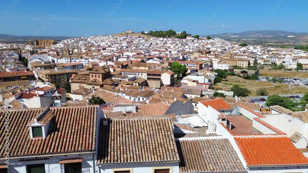 Drone flight over the old town of Antequera, Spain overlooking historic and rural areas with a lot of typical andalusian white houses, narrow streets and old churches. Mountains in the background. Drone flight over the old town of Antequera, Spain overlooking historic and rural areas with a lot of typical andalusian white houses, narrow streets and old churches. Mountains in the background.