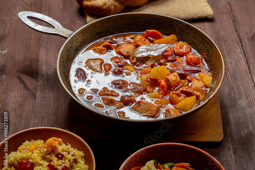 Hot thick cholent in a cast iron pan on the festive table for the meal on Rosh Hashanah photo