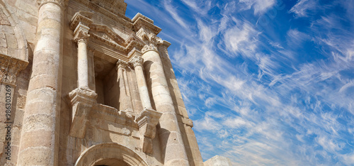 Arch of Hadrian in Gerasa (Jerash)-- was built to honor the visit of emperor Hadrian to Jerash in 129/130 AD, Jordan. Against the background of a beautiful sky with clouds #986303269