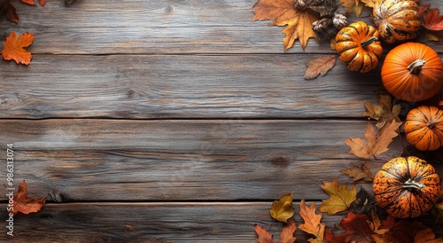 Autumn arrangement of pumpkins and colorful leaves on a rustic wooden table i...