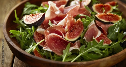 Delicious fig and prosciutto salad with arugula and cheese on a rustic wooden table