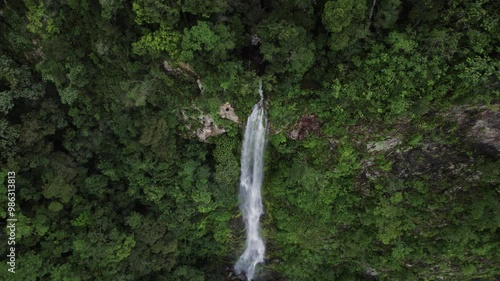 Aerial shot of a magnificent waterfall nestled within a lush tropical jungle.