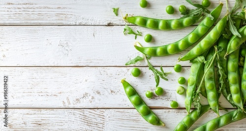 Fresh green peas and pods arranged on a rustic wooden table with scattered peas