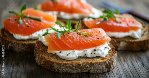 Delicious smoked salmon on rye bread with cream cheese and herbs arranged on a wooden table