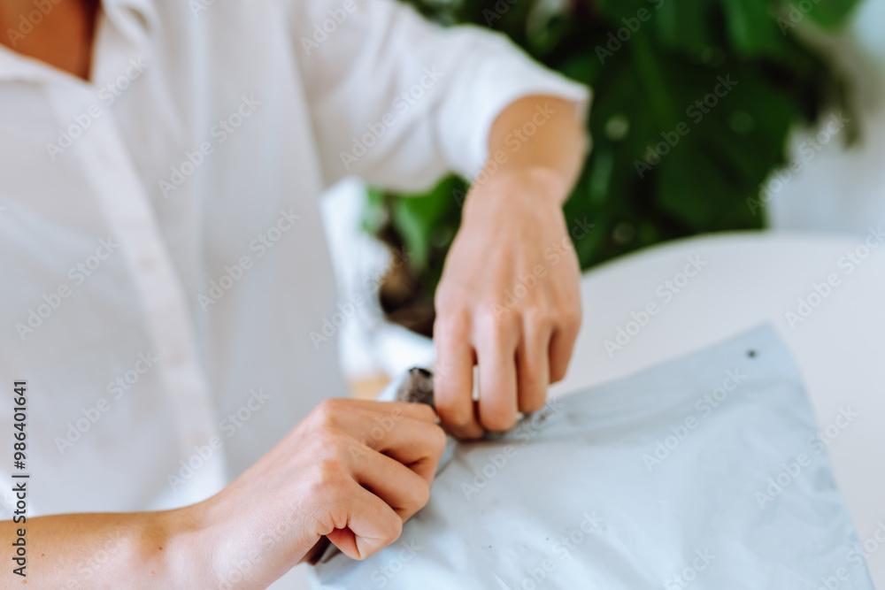 hands of young woman unpacking plastic bag parcel, buying goods online, hands of young woman unpacking plastic bag parcel, buying goods online,