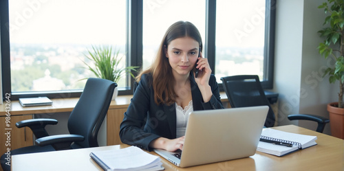 A confident businesswoman is discussing a new strategy over the phone in a bright and productive office. 