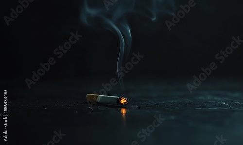 Burning cigarette with smoke on dark background. photo