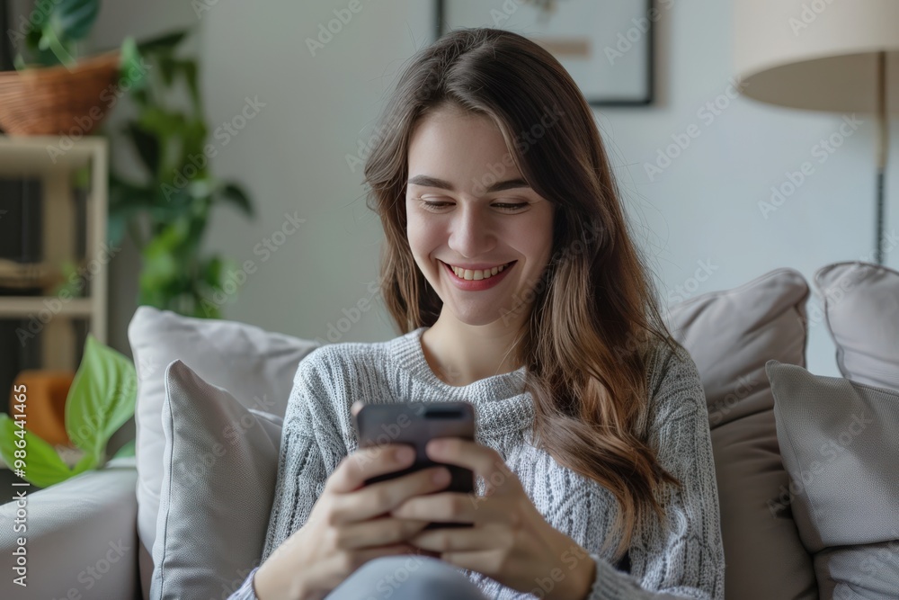 A woman is sitting on a couch and smiling while looking at her cell phone generative ai A woman is sitting on a couch and smiling while looking at her cell phone generative ai