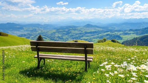 A wooden bench sits peacefully amidst a field of wildflowers, offering a perfect view of the rolling green hills and valleys under a bright, sunny sky. A tranquil scene invites relaxation