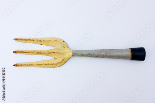 An old rusty garden fork. Garden forks are essential for tasks like loosening and turning over soil, raking out stones and weeds, breaking up clods, and aerating soil. photo