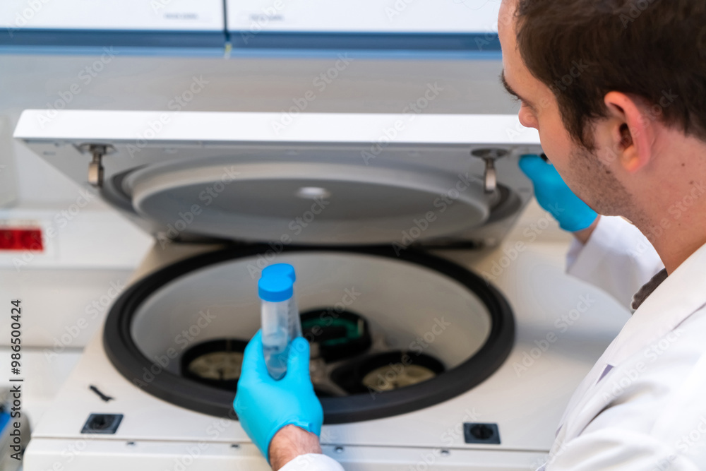 Obraz premium Laboratory technician using refrigerated centrifuge machine in blood bank, Benchtop Centrifuges, Device for laboratory research. Modern lab technologies. Medical Research Centrifuge.