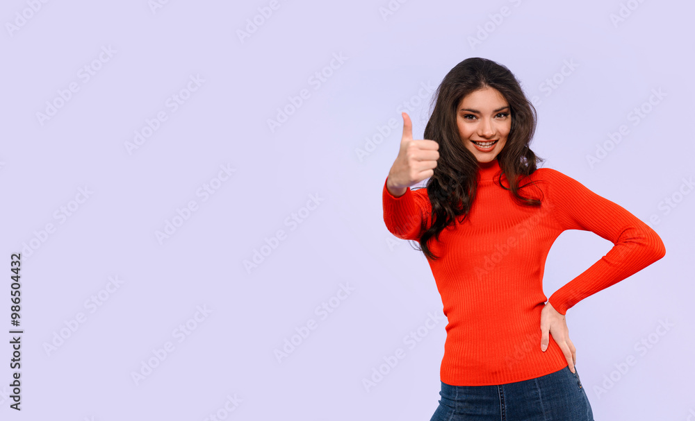 The Joyful Woman Smiles Broadly, Showing Her Enthusiasm With a Thumbs-Up The Joyful Woman Smiles Broadly, Showing Her Enthusiasm With a Thumbs-Up