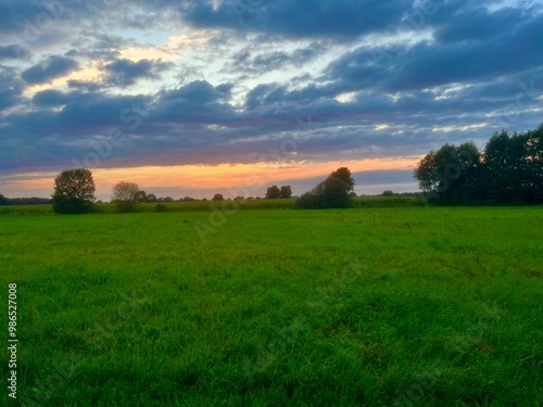 beautiful sunset sky in the green field, countryside