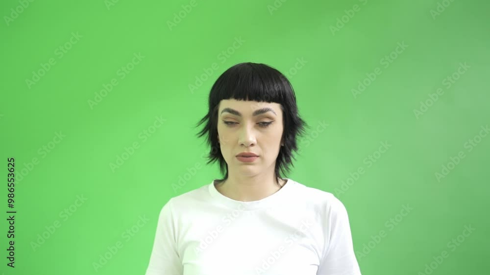 Woman Holding Finger To Lips In Shush Gesture Against Green Background Woman Holding Finger To Lips In Shush Gesture Against Green Background