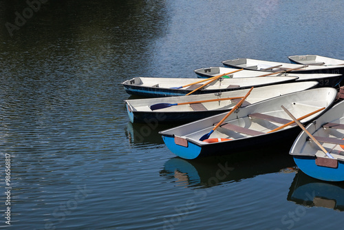 A Peaceful Scene Of Several Rowboats Moored On Still Water, Evoking Tranquility And Simplicity In Nature.