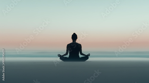 Silhouette of a person in a seated meditation pose on a calm beach at dawn. The sky transitions from soft pink to blue hues, creating a peaceful and reflective atmosphere along the horizon.