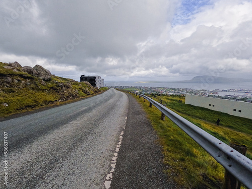 Aerial views looking out over the Capital city of the Faroe Islands, Tórshavn. The North Atlantic Ocean and the small remote island of Nolsoy can be seen in the distance. Winding road. photo