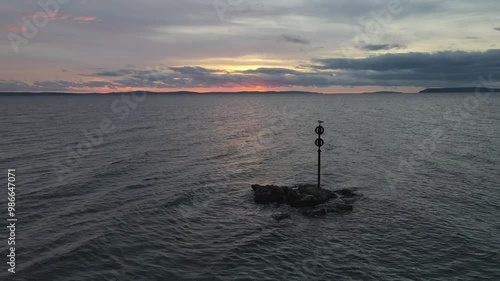 Wallpaper Mural Steady drone footage captures a serene sunset over the Adriatic Sea near Split, Croatia, with a seagull perched on a marker pole on a small rock, highlighting the tranquil coastal scene. Torontodigital.ca