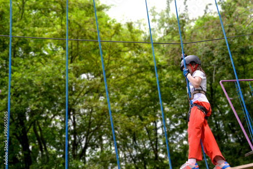 adventure climbing high wire park - people on course in mountain helmet and safety equipment. High quality photo. High quality photo